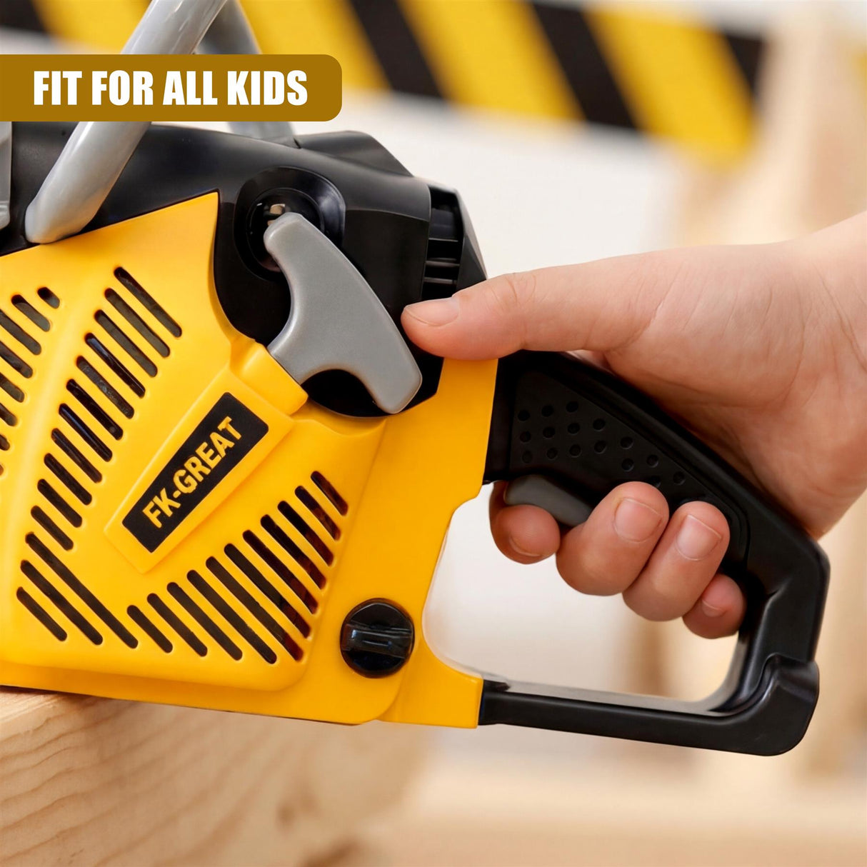 A hand grips a bright yellow plastic toy chainsaw that rests on a light wooden surface.
