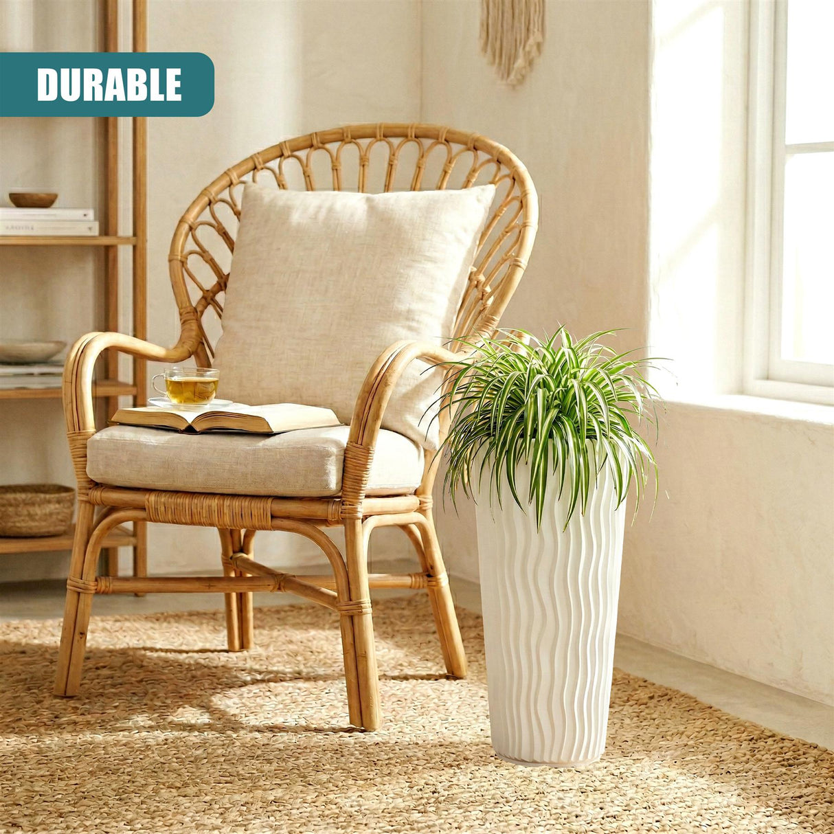 A white, ribbed flower pot holds green foliage next to a beige cushion on a wooden wicker chair.