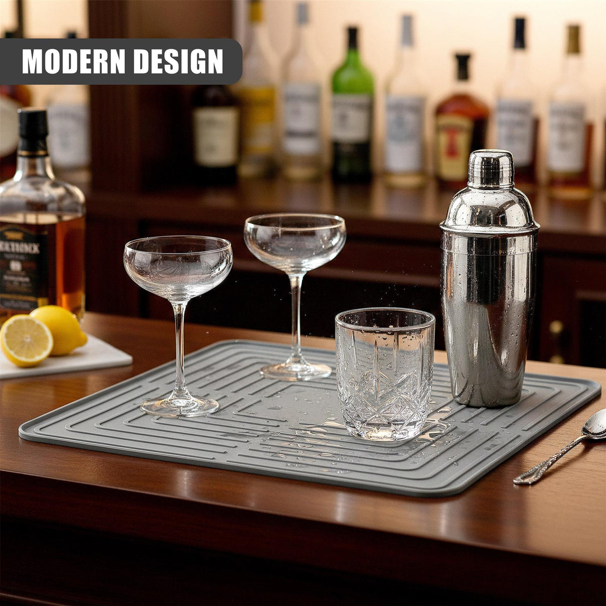 Three empty glasses and a silver container rest on a gray drainer drying mat.