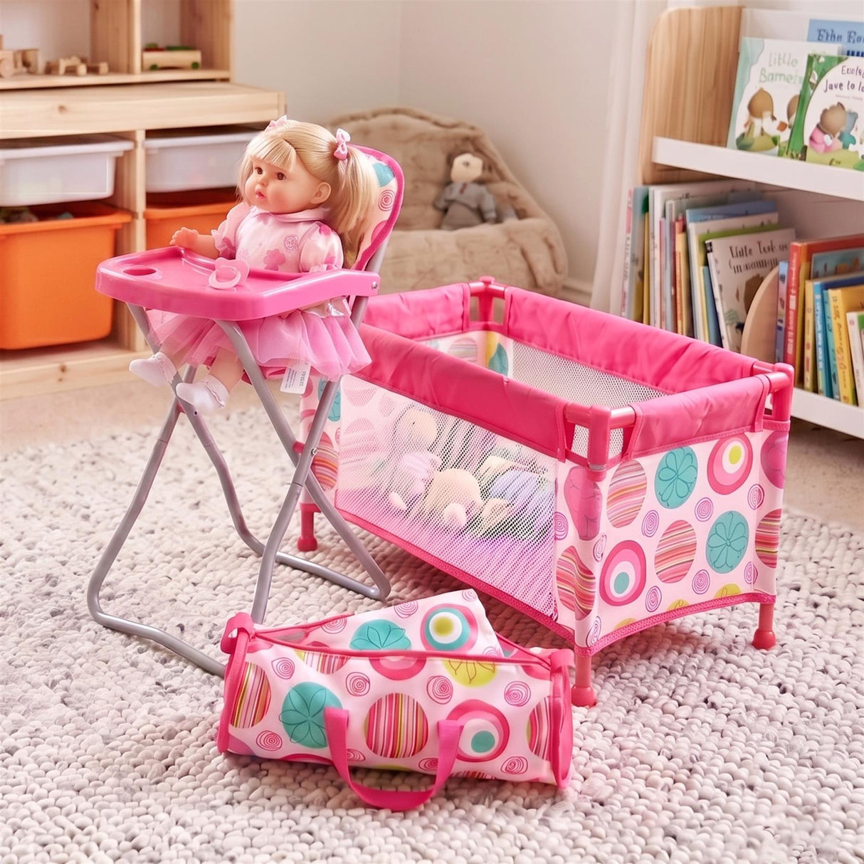 Folding pink high chair, patterned cot, and matching carry bag displayed together on a neutral rug.