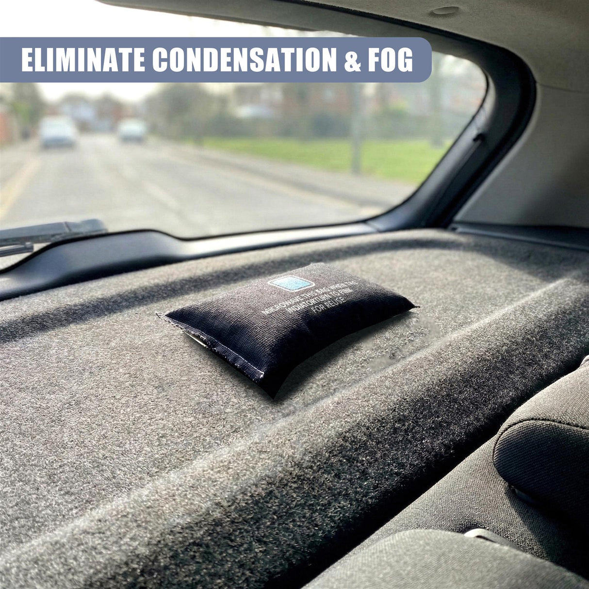 A small, black packet dehumidifier sits on the car's dashboard, viewed through the windshield.