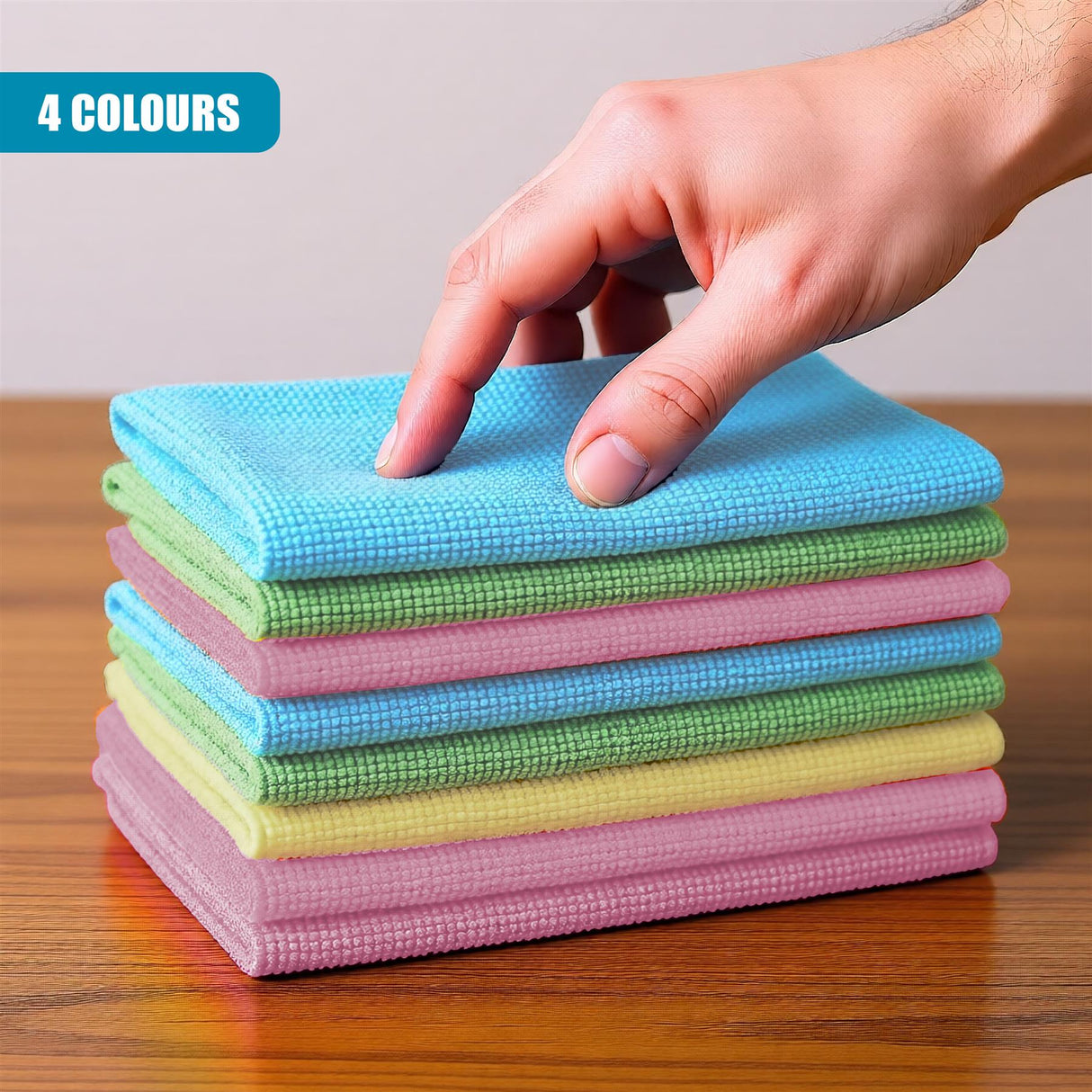 Stack of folded microfiber cloths in various pastel colors, held by a person's hand.