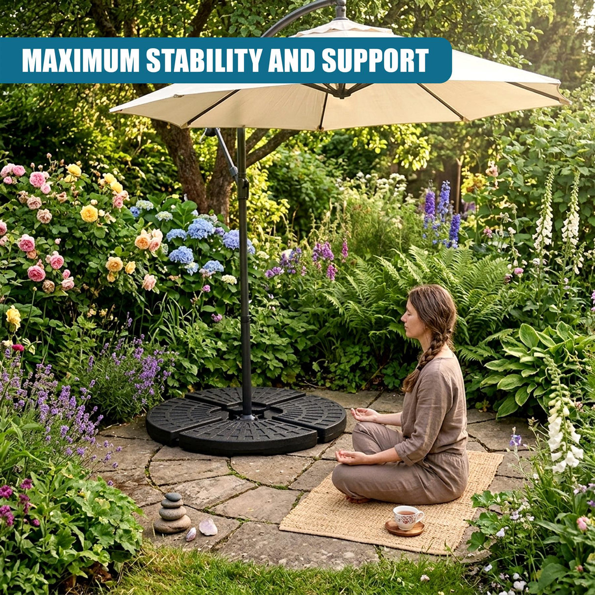 Round patio base supports a large parasol positioned in a lush, flowered garden setting.