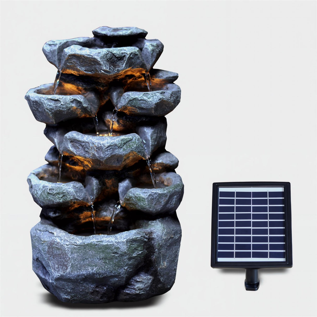Tiered, dark gray rock waterfall structure with visible flowing water and an attached solar panel.