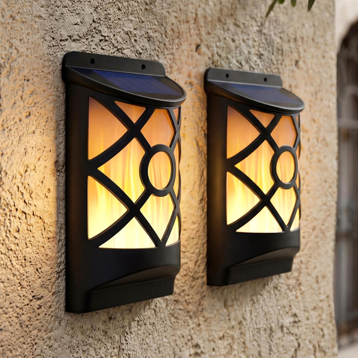 Two rectangular black outdoor sconces with decorative paneled glass are mounted on a textured stucco wall.