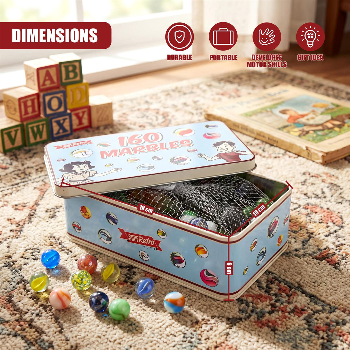 A blue and white marble tin box rests on a rug, surrounded by alphabet blocks and loose colored marbles.