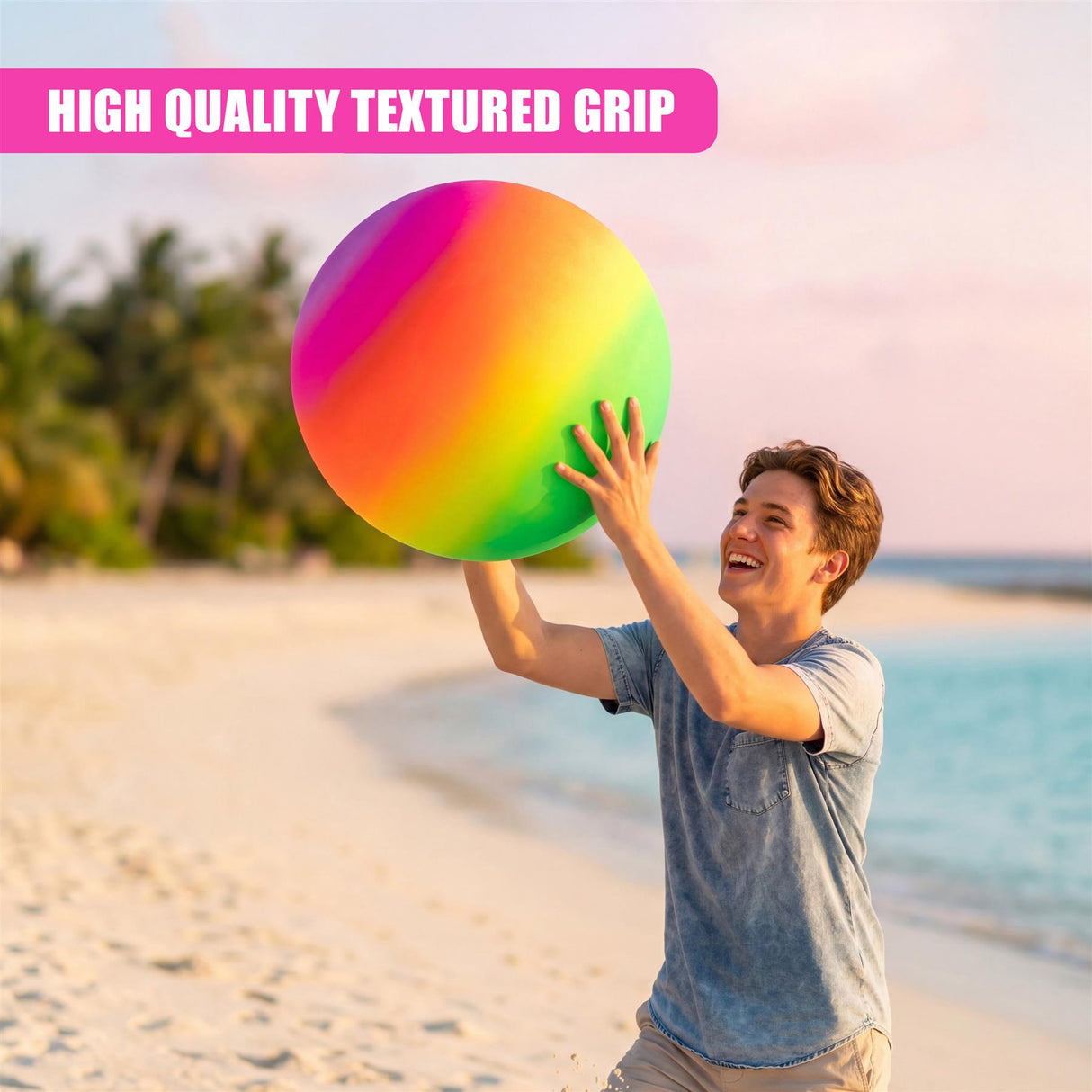 A smiling man holds a large, multi-colored rainbow ball on a sunny beach.