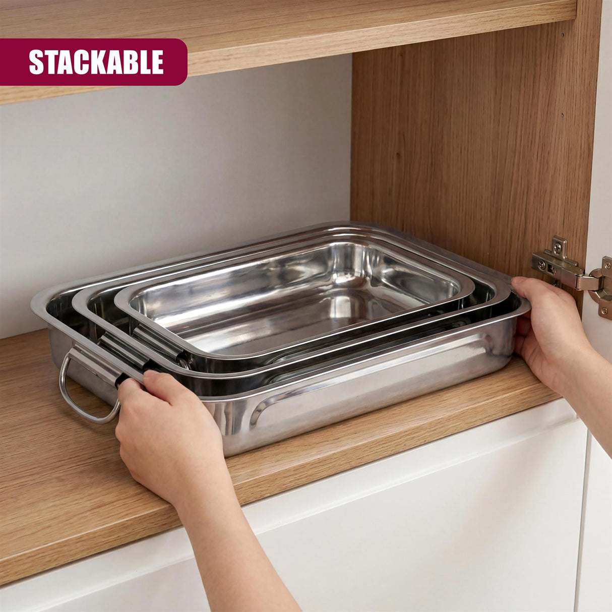 Three stacked stainless steel roasting trays are visible on a wooden shelf.
