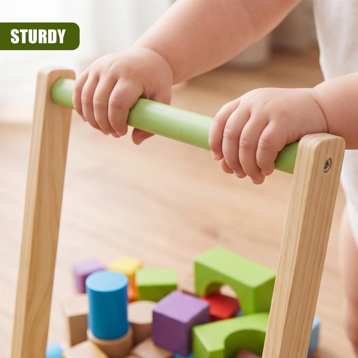 Wooden baby walker with a green bar is shown, surrounded by multi-colored wooden blocks on the floor.