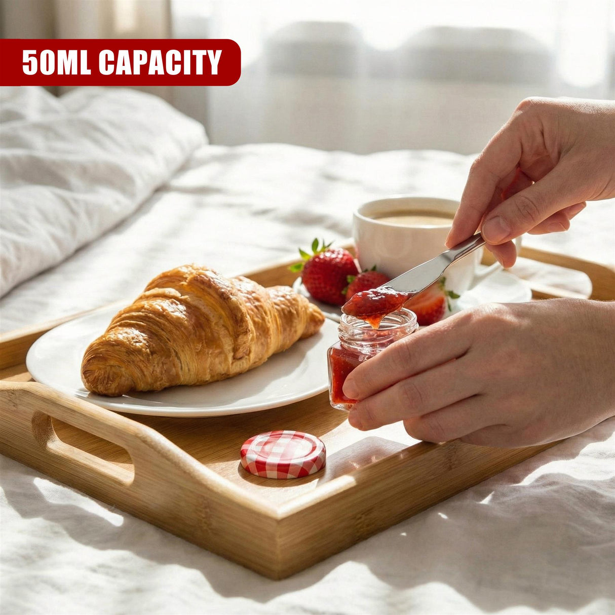 Mini glass jars, a croissant, strawberries, and coffee cup displayed on a wooden tray.