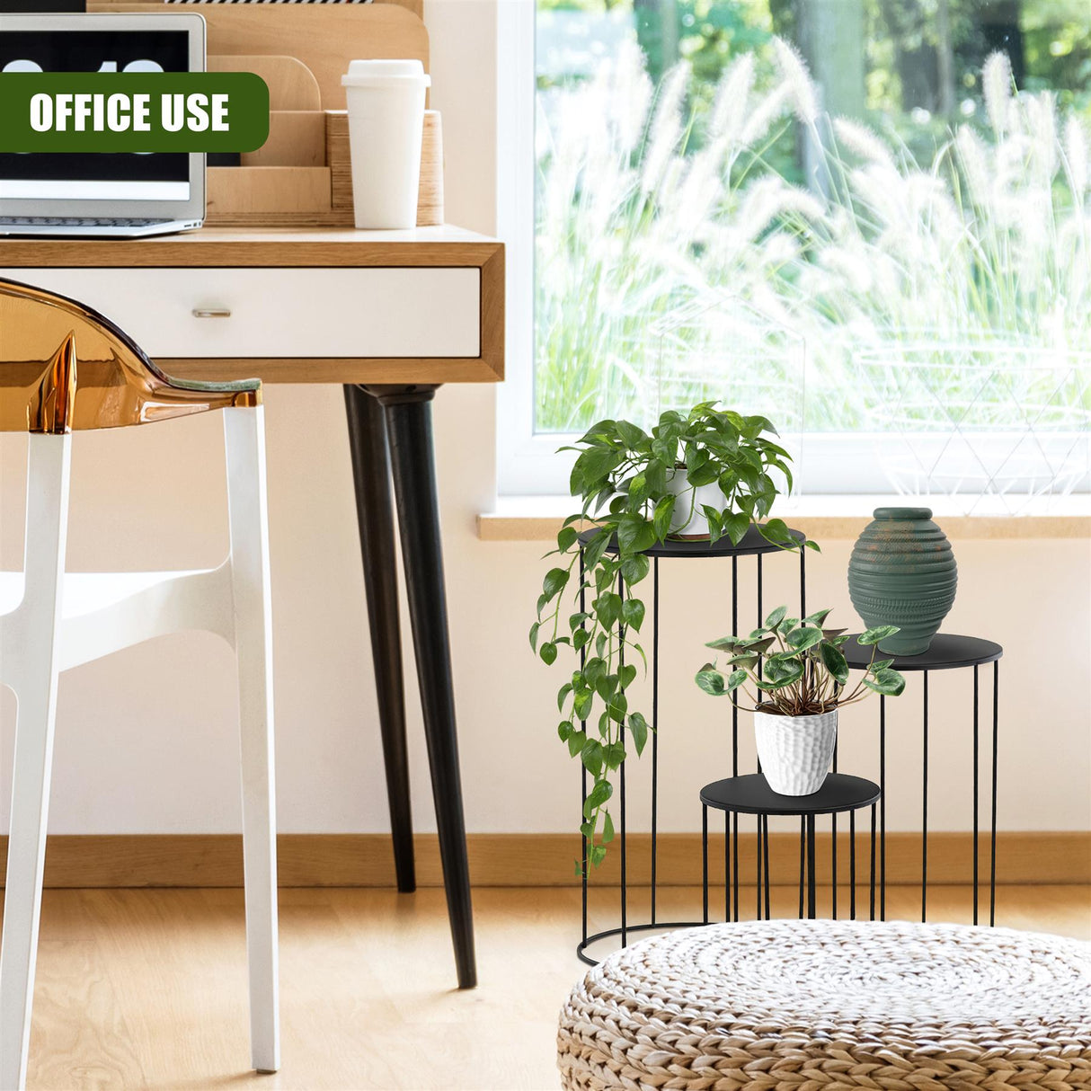 Set of three black tiered plant stands holding potted green foliage and a decorative vase.