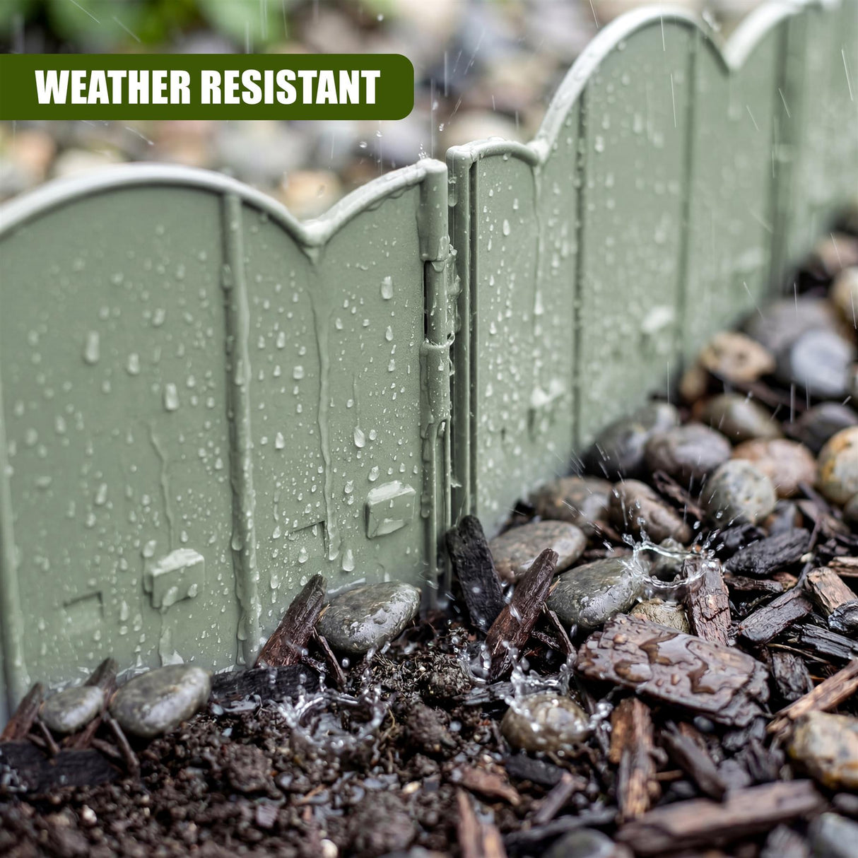 Green garden edging fence, wet with raindrops, positioned on dark soil and mulch.