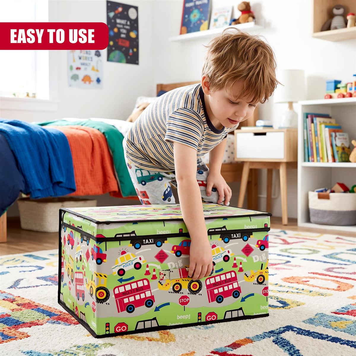A young boy in a striped shirt and patterned trousers is reaching into a large Road Works Large Storage Box featuring