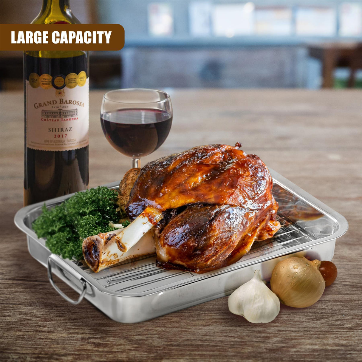 Metal roasting tray with rack, holding roasted chicken, herbs, garlic, and onion.