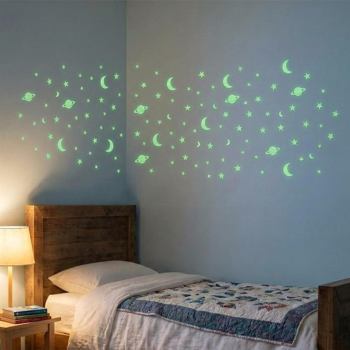 A child's bedroom with a wooden bed and a nightstand with a lamp and books. The wall above the bed features a glow-in-the-dark star and moon sticker set. - UKBuyZone