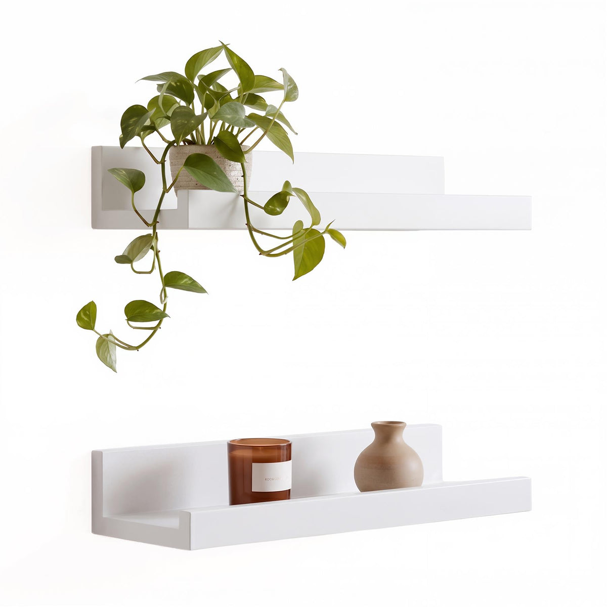 White wall hanging shelf pack of two from GEEZY displaying a plant and candle