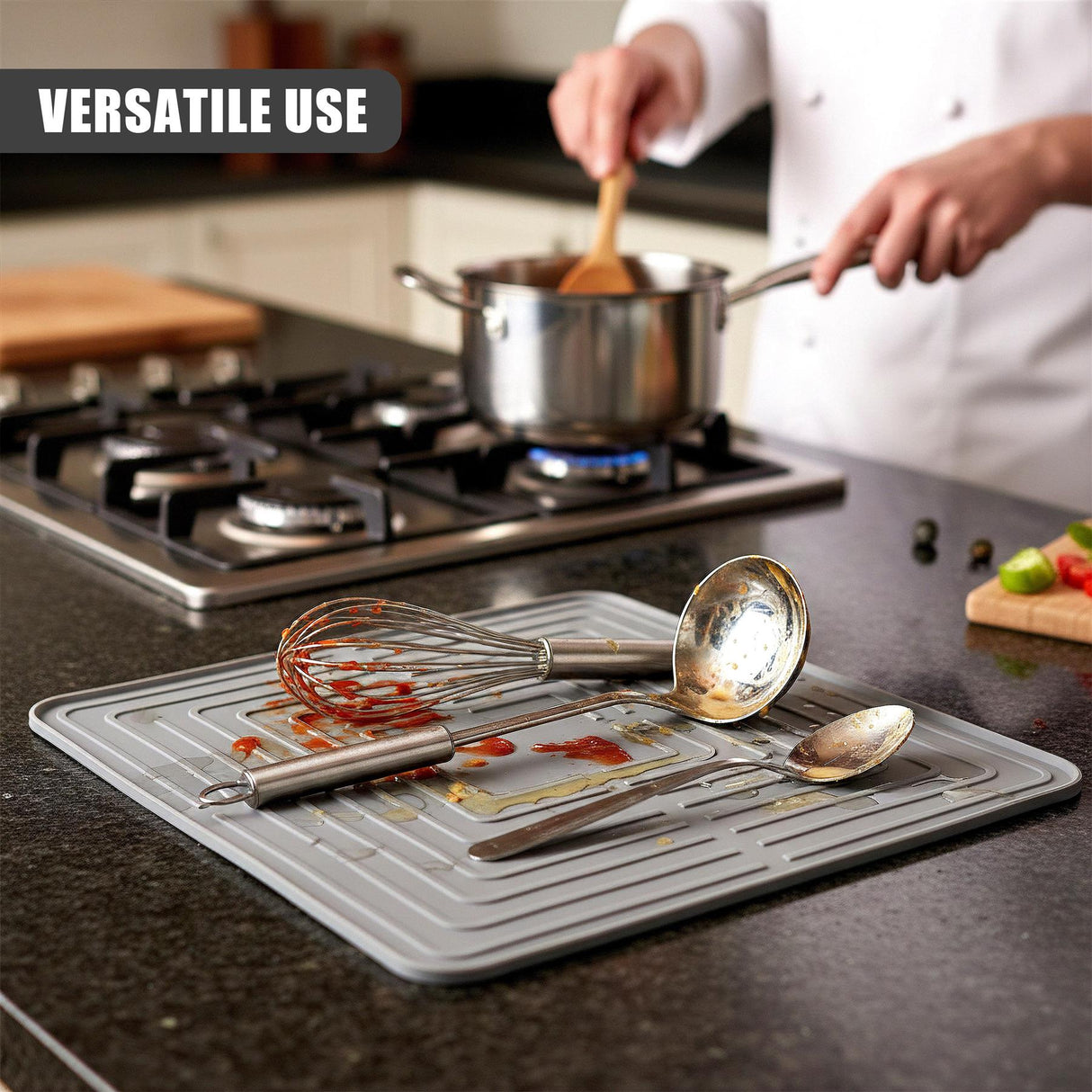 Draining mat holding a whisk and various metal measuring spoons on a dark countertop.