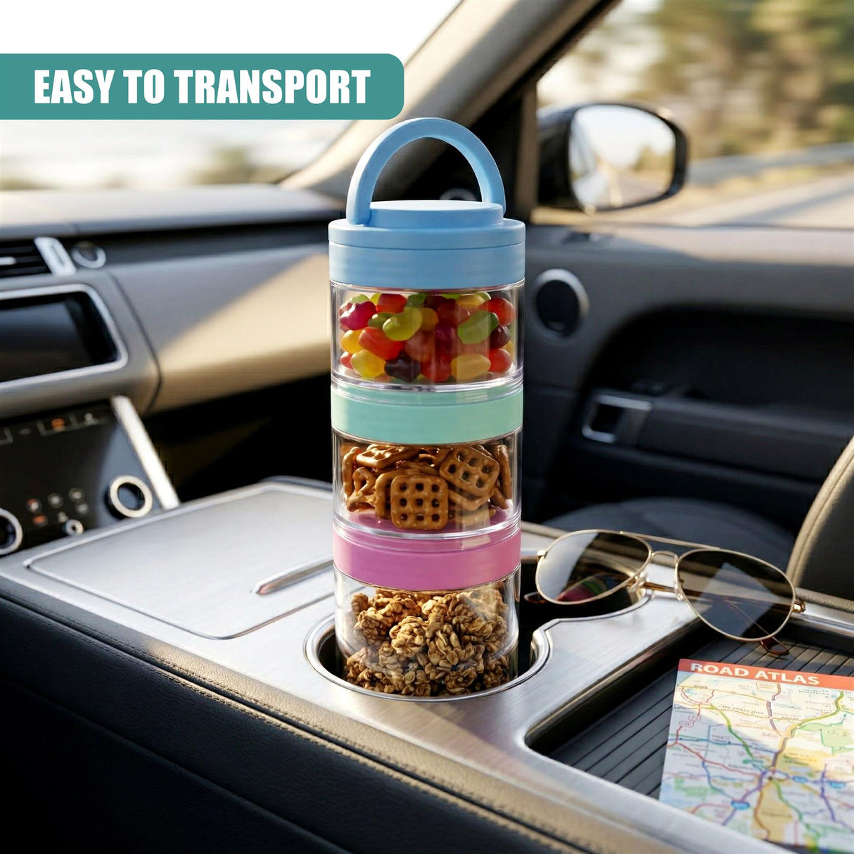 Three stackable snack pots filled with snacks sit on a car dashboard next to sunglasses and a folded map.