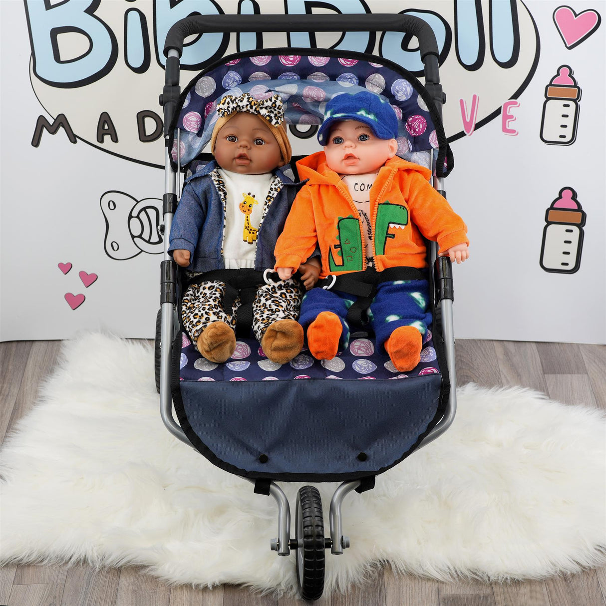 Blue twin pushchair with two dolls, one boy and one girl, sitting in the seats.