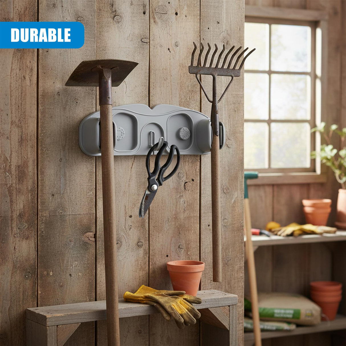 Wall-mounted gray holder organizes a broom, mop head, and additional tools on rustic wood paneling.