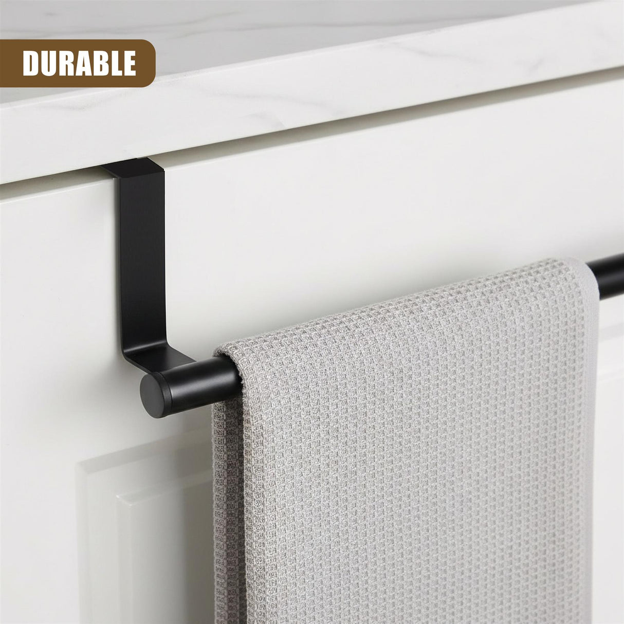 Black towel rail mounted on a white cabinet, holding a folded, textured light gray kitchen towel.