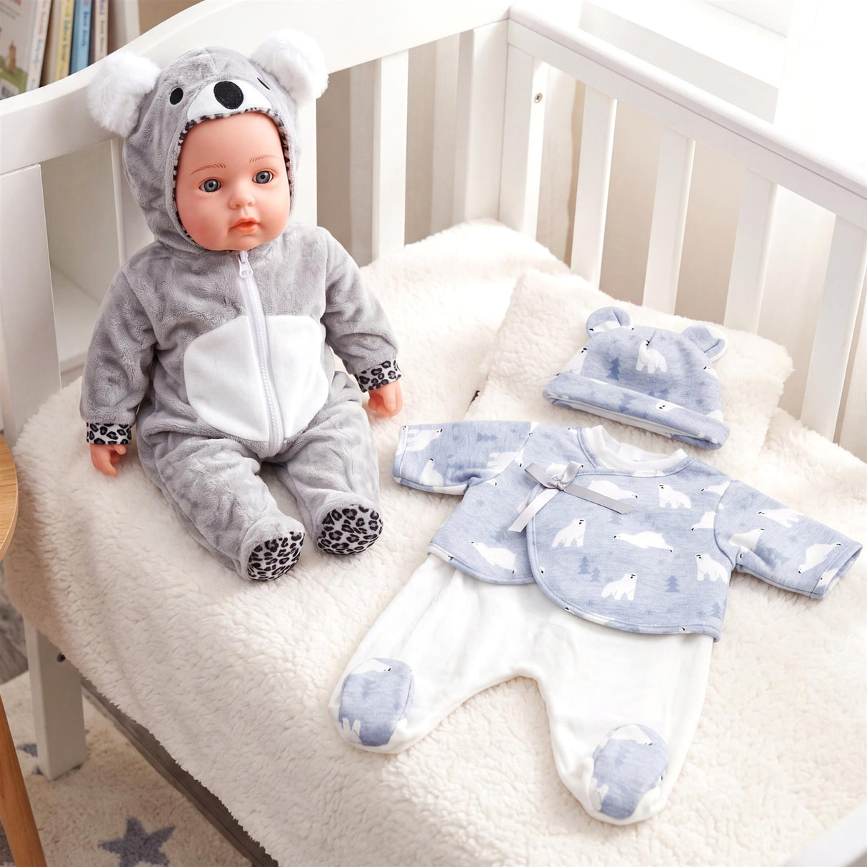 Doll in a koala costume rests near a two-piece polar bear pattern doll clothes set.