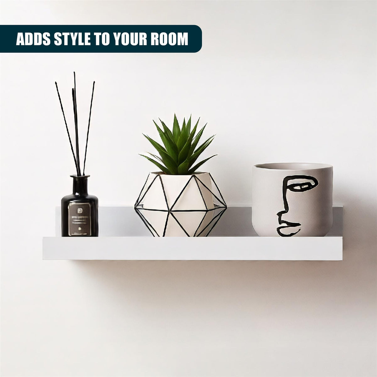 White wall hanging shelf displaying a reed diffuser, geometric plant pot and face design mug