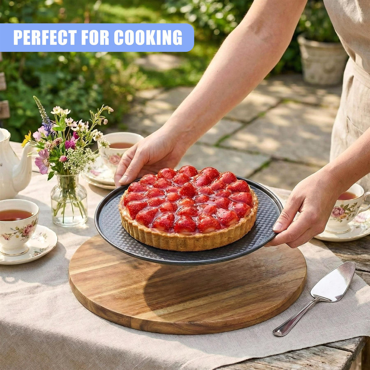 A finished cake on a plate rests on a wooden board with a serving spatula nearby.