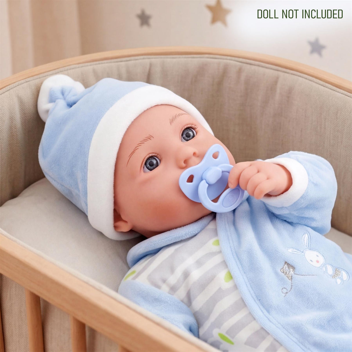 Doll model in a crib wearing blue, striped pajamas and holding a pacifier.
