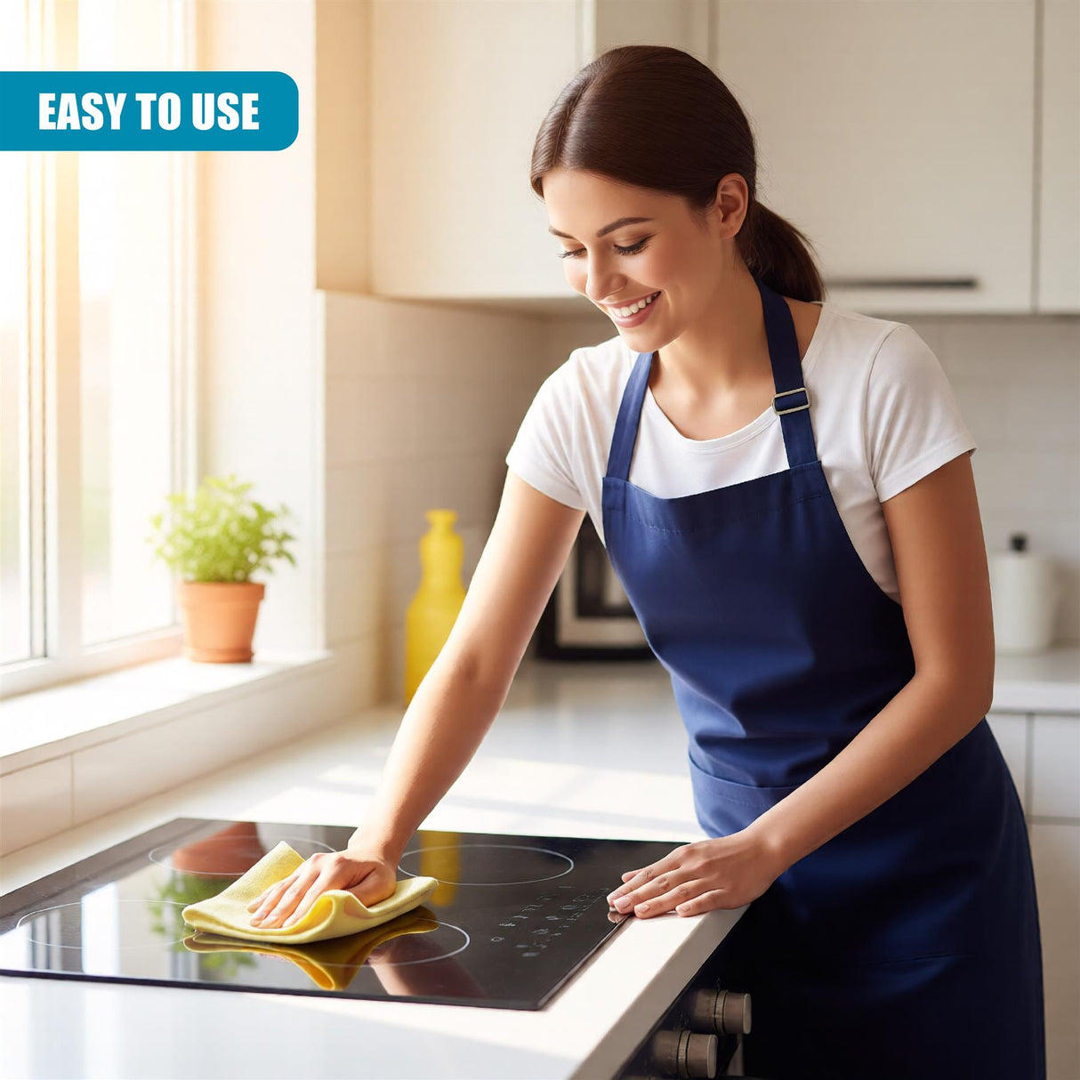 A woman cleans a shiny kitchen stove surface with a yellow microfiber cloth.