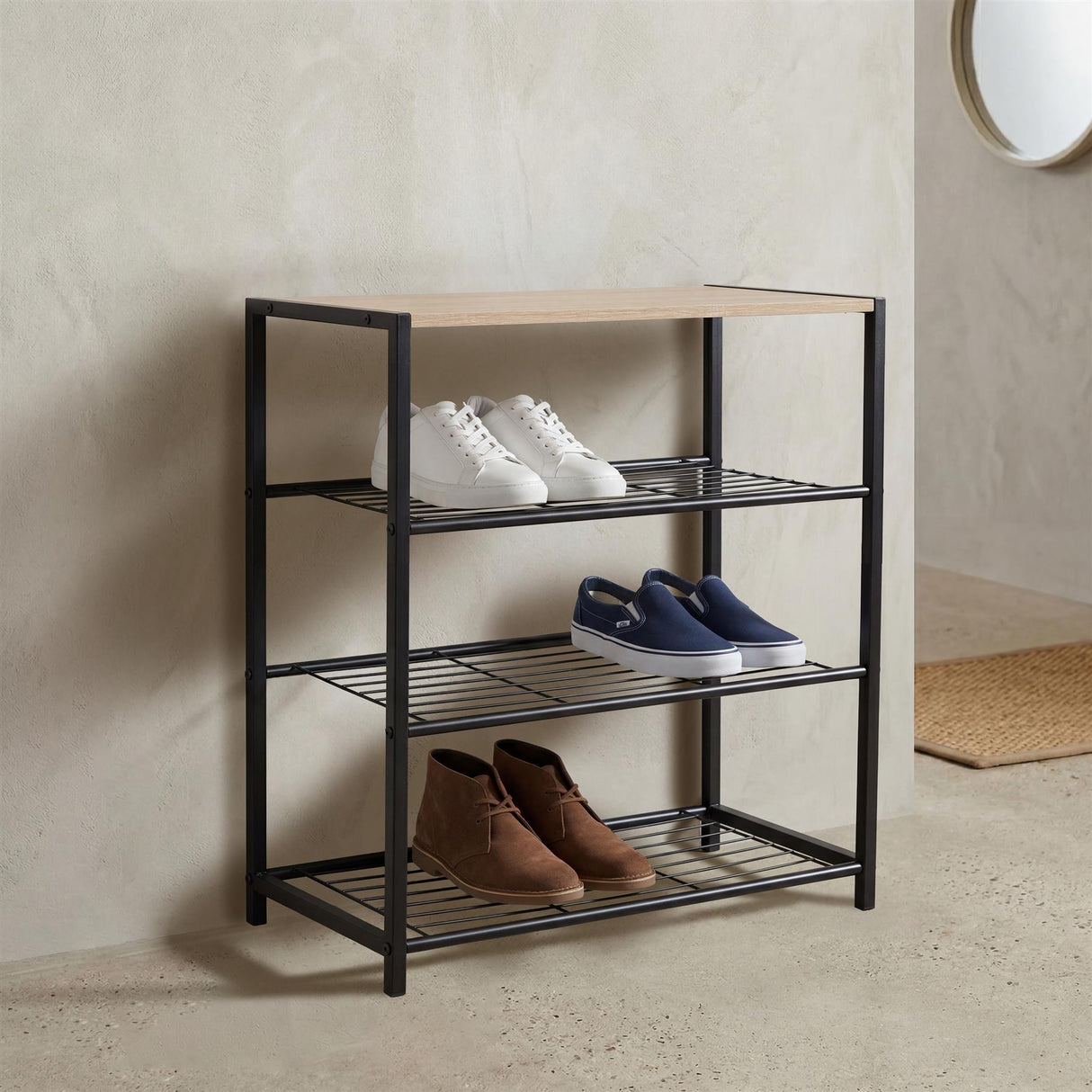 Black tiered shoe rack with wooden seat holding white, navy, and brown shoes on the shelves.