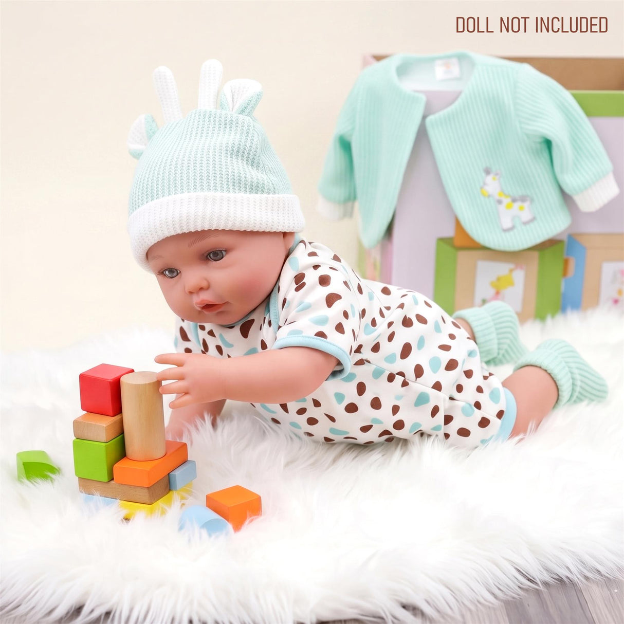 Mint green reborn doll outfit, jacket, and pants are displayed next to the model playing with blocks.