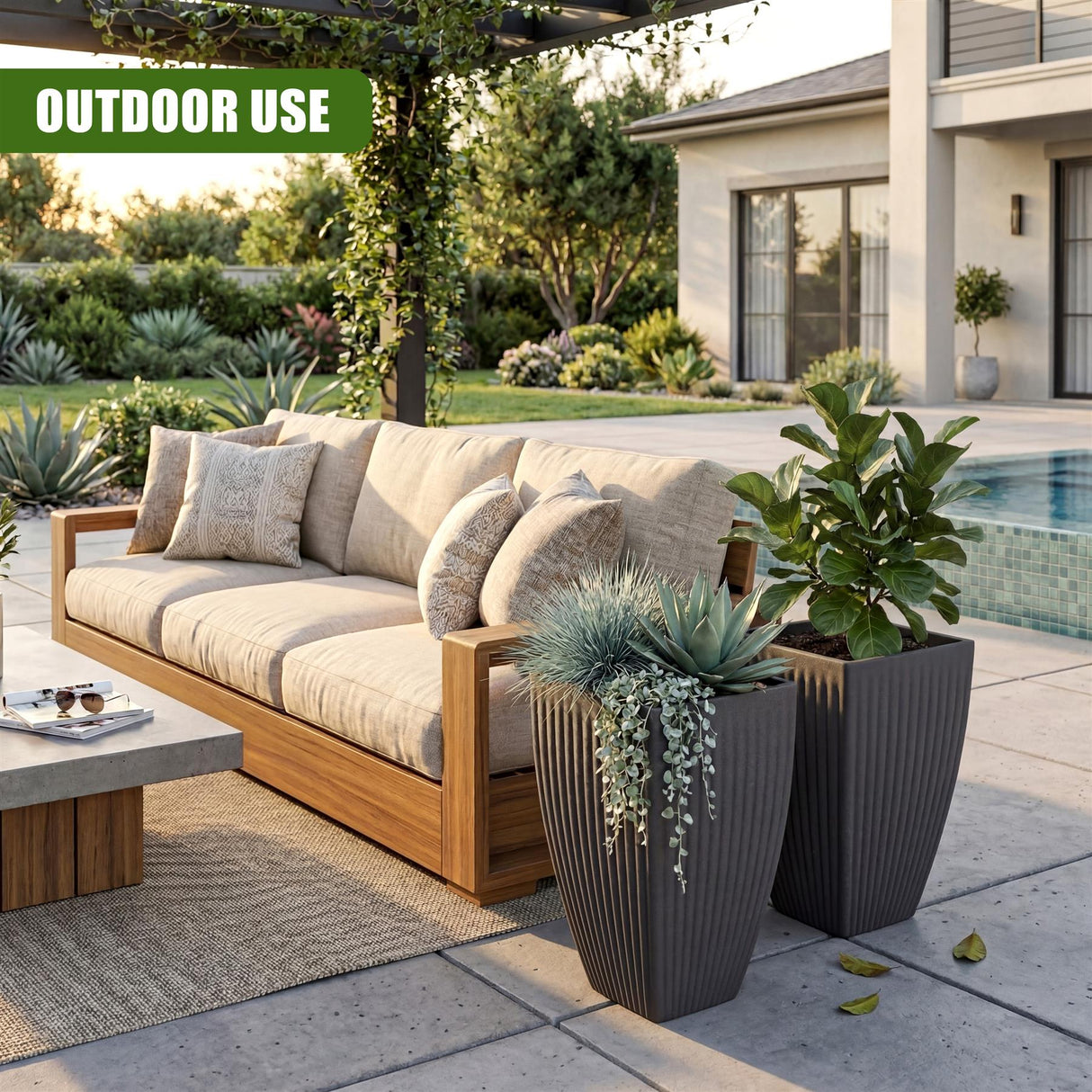 Tall, dark gray rectangular planter pot holding various leafy plants and succulents outdoors.