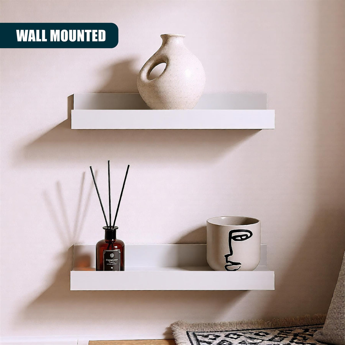 White wall mounted floating shelves from GEEZY displaying a vase, reed diffuser and mug against a pink wall