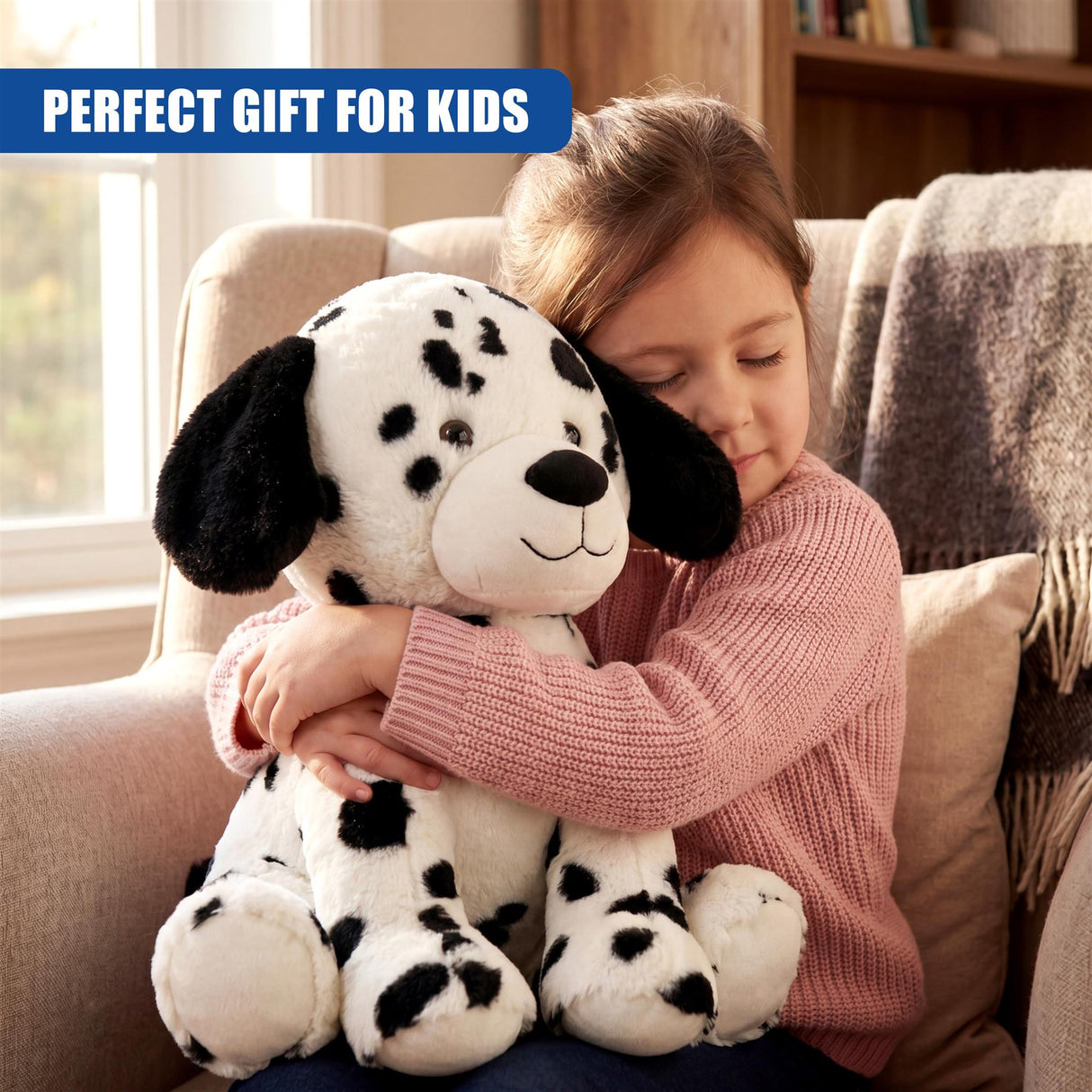 Child sitting on sofa embracing a black and white spotted Dalmatian plush toy.