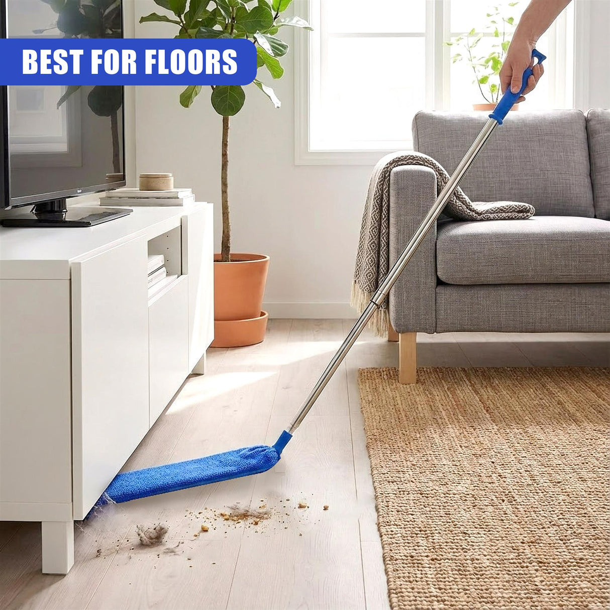 A silver extendable duster pole cleans dust from a light wooden floor surface.