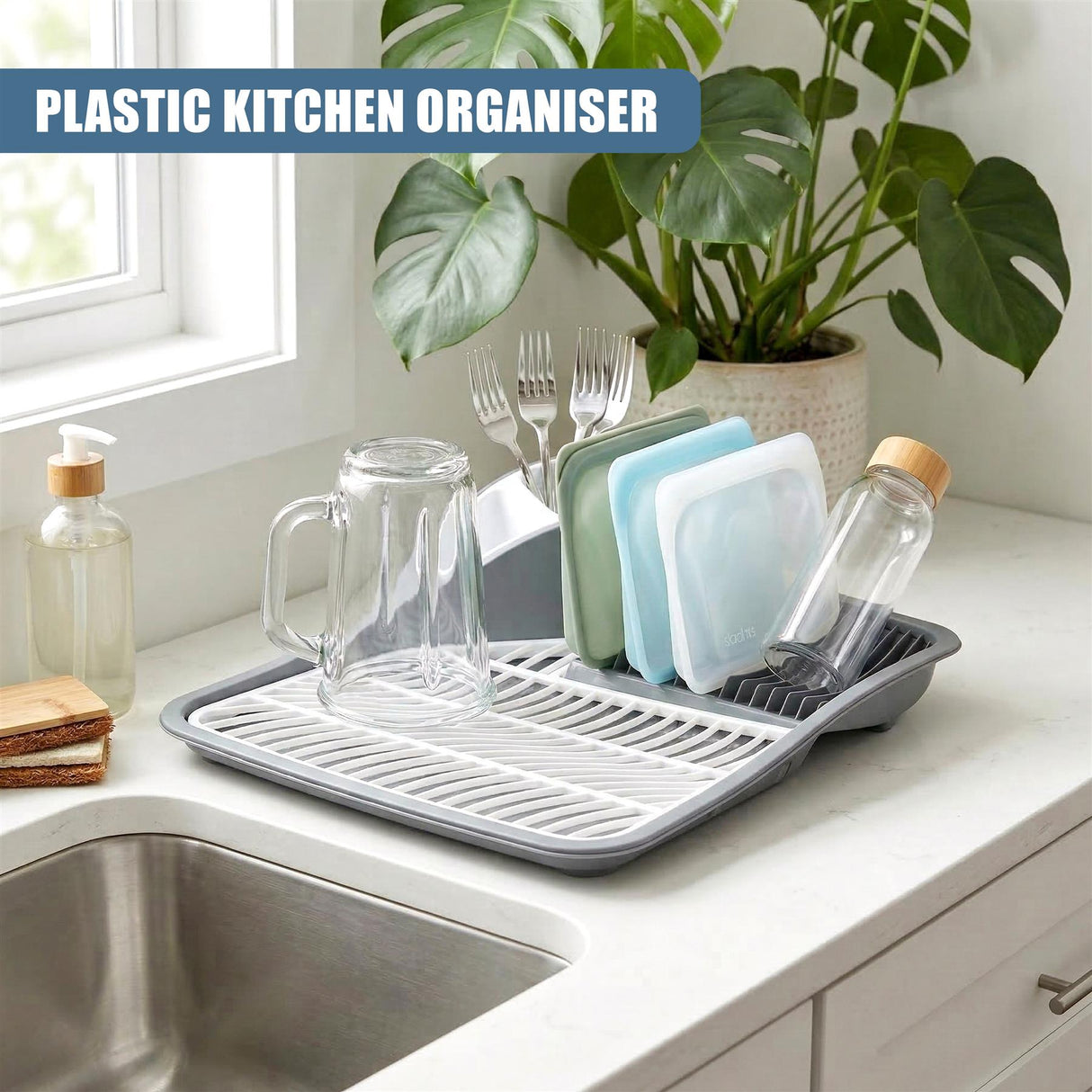 Gray plastic dish drying rack holds glassware, utensils, and bottles on a kitchen counter.