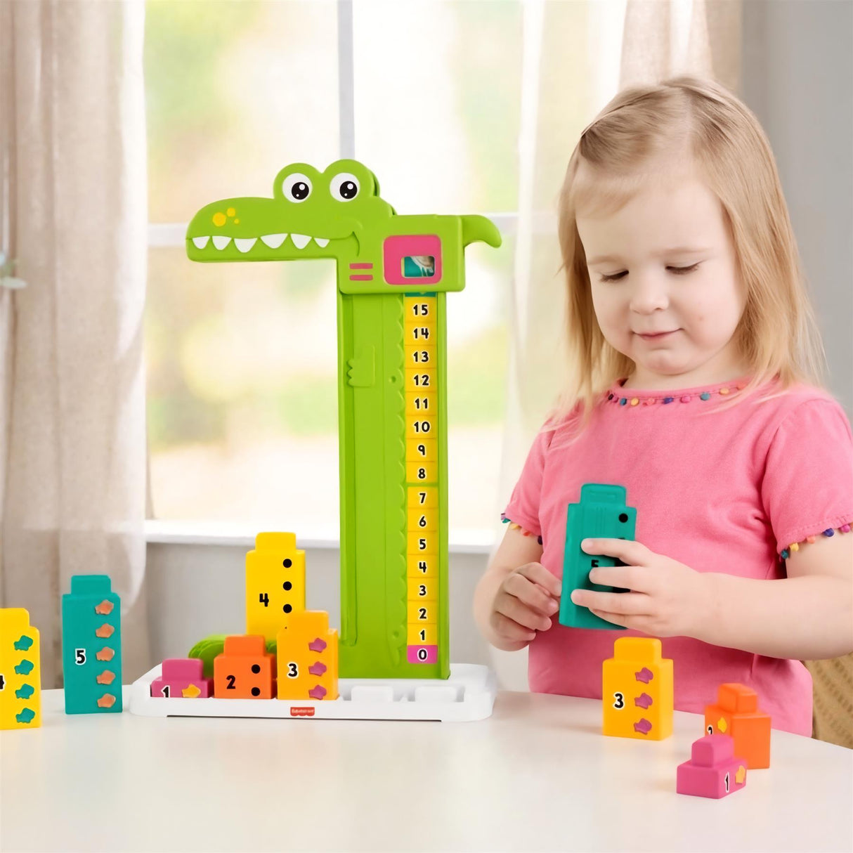 A young girl plays with a green alligator math toy and brightly colored counting blocks on a white surface.