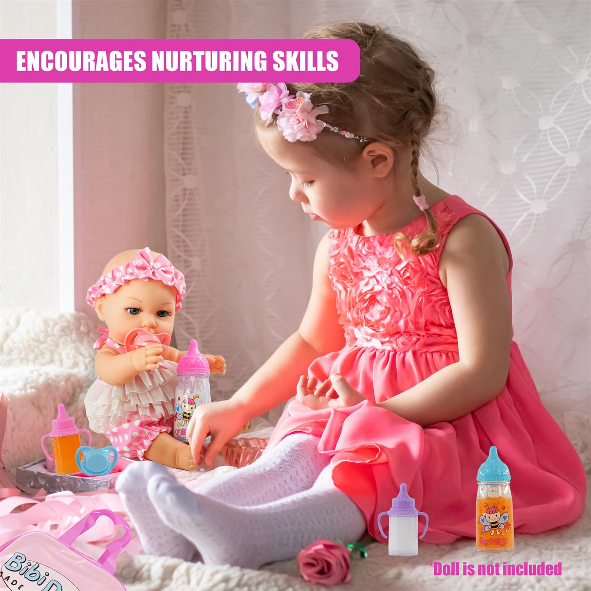 A young girl interacts with a doll near various baby items, including bottles and a pink blanket.