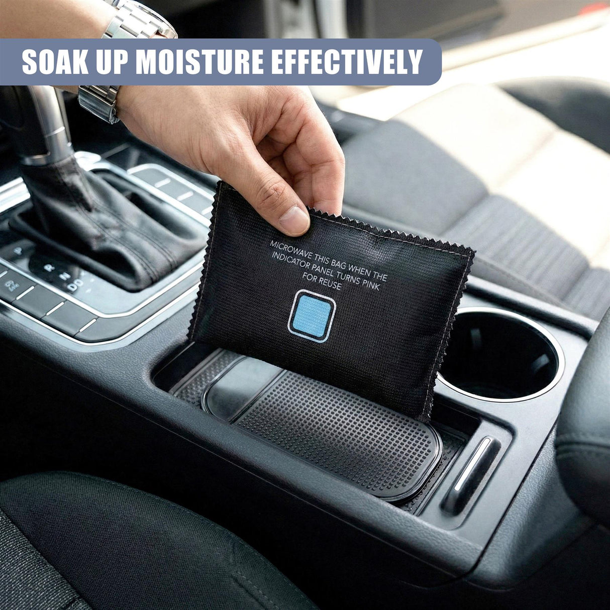 Hand placing a black, rectangular dehumidifier bag into the vehicle's cup holder.