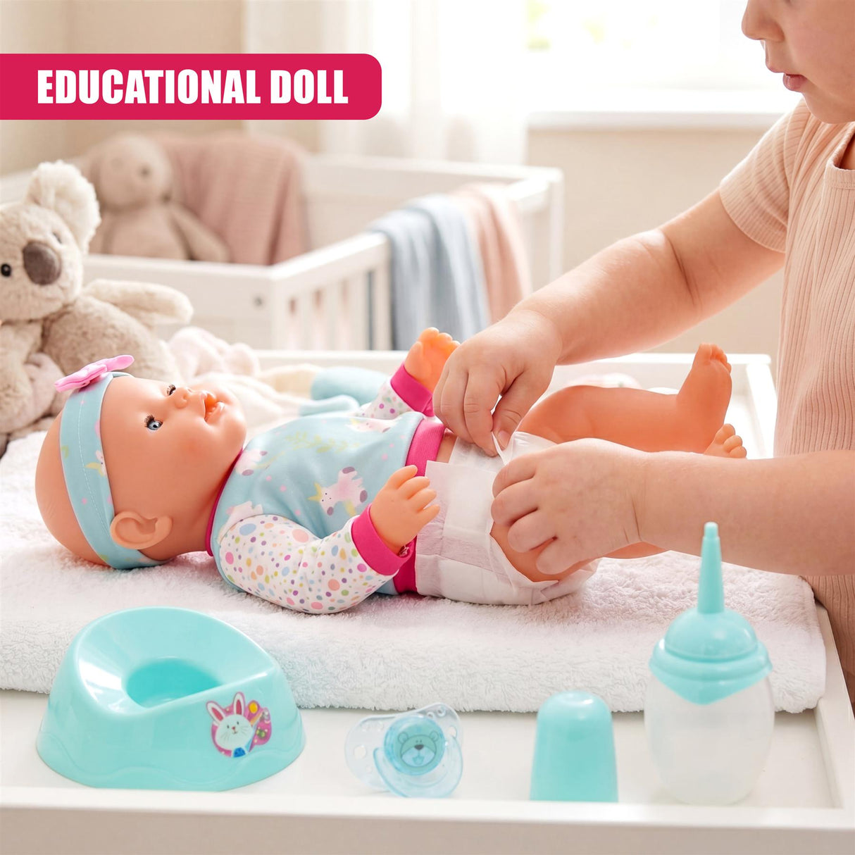 Child's hands are dressing a doll on a crib, with plastic pacifier and bottle accessories visible.