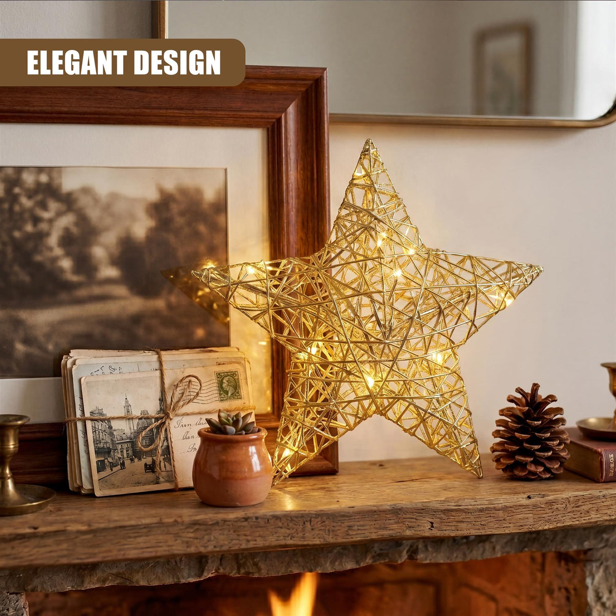 A champagne gold hanging LED Christmas star by GEEZY sits on a wooden mantelpiece next to a framed picture, postcards and a