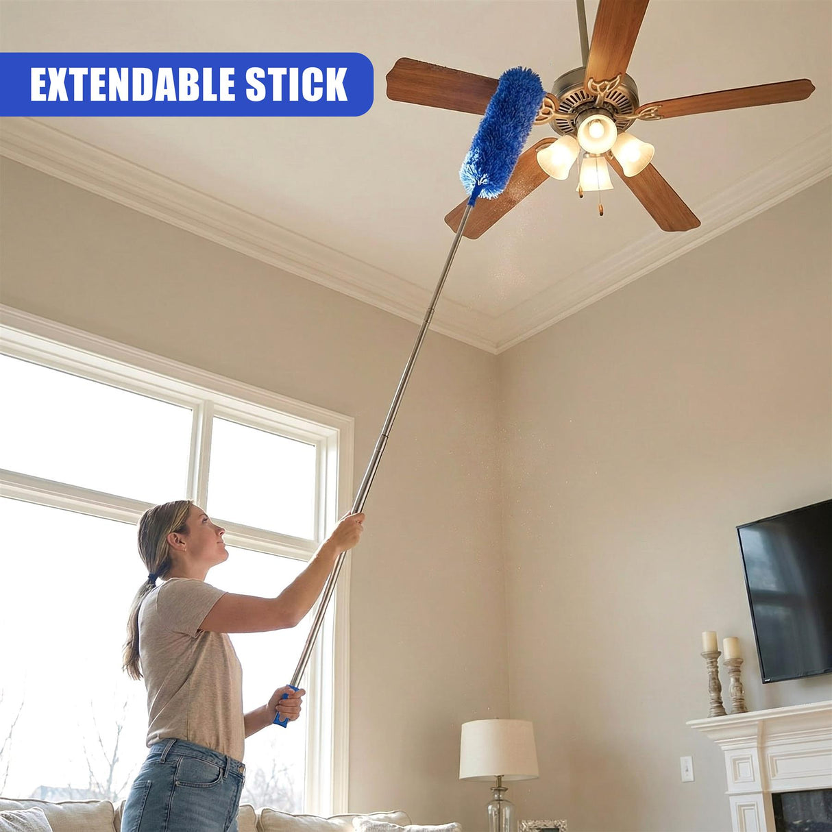 A woman cleans a ceiling fan using an extendable pole and blue microfiber duster attachment.