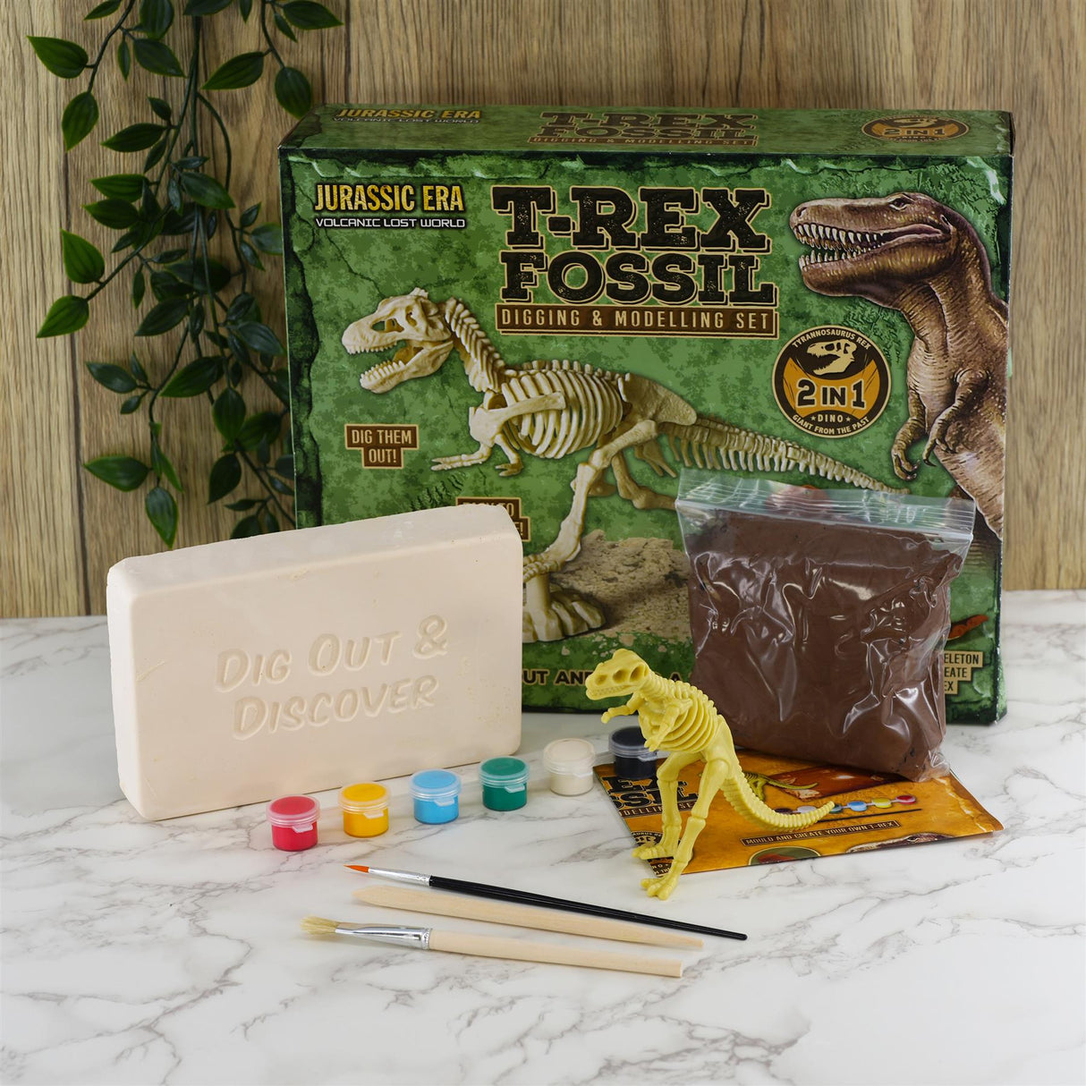 Fossil excavation kit shows a box, pink digging block, brown modeling material, and yellow dinosaur skeleton.