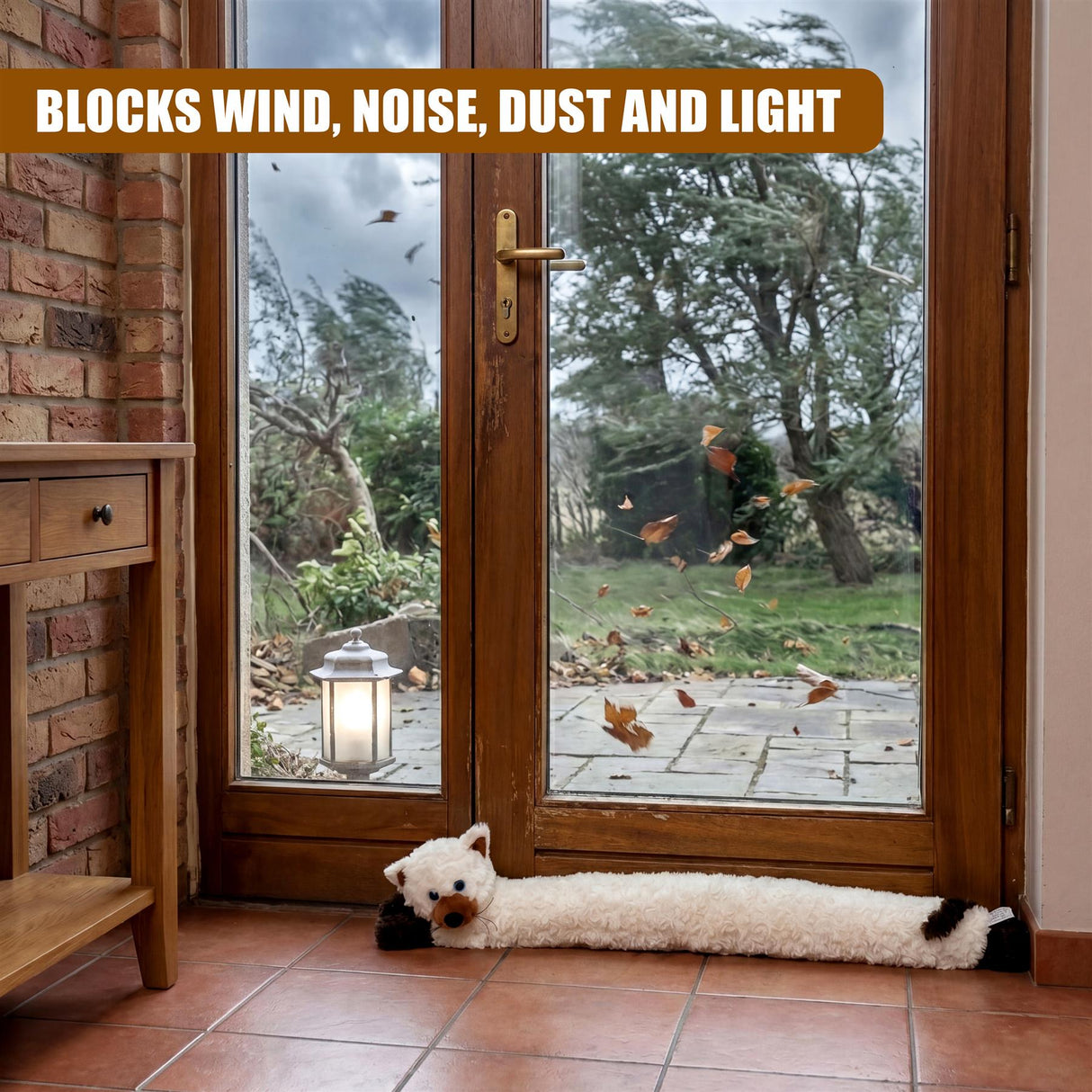 The cream cat draught excluder lies on the floor in front of the large glass double doors.