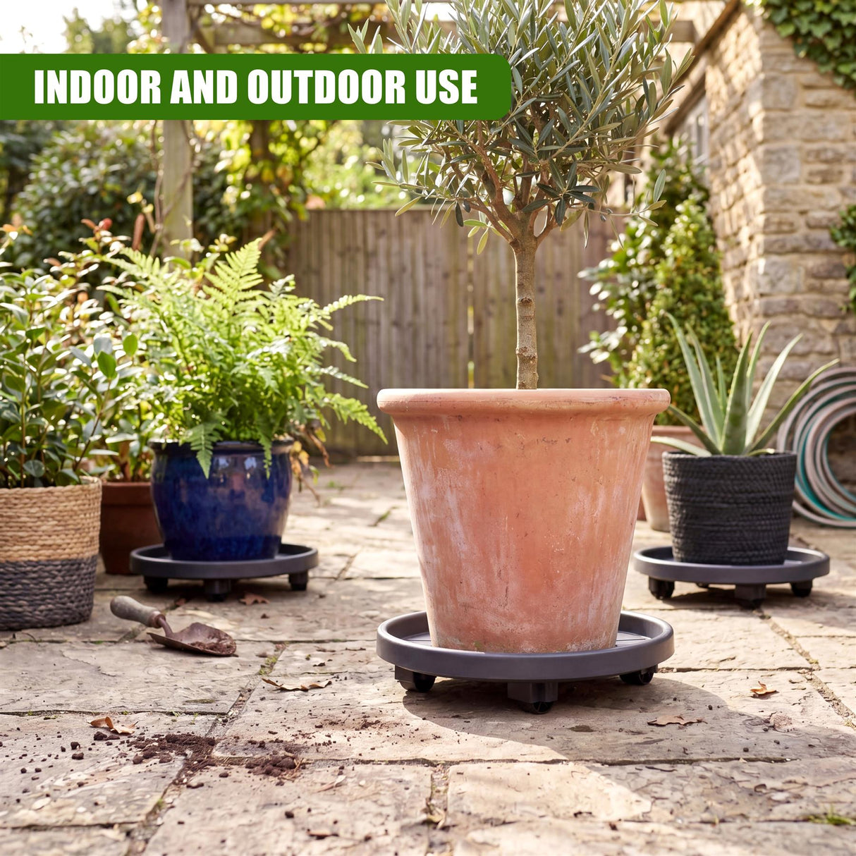 Terracotta pot placed on a dark, wheeled round caddy resting on stone pavers.