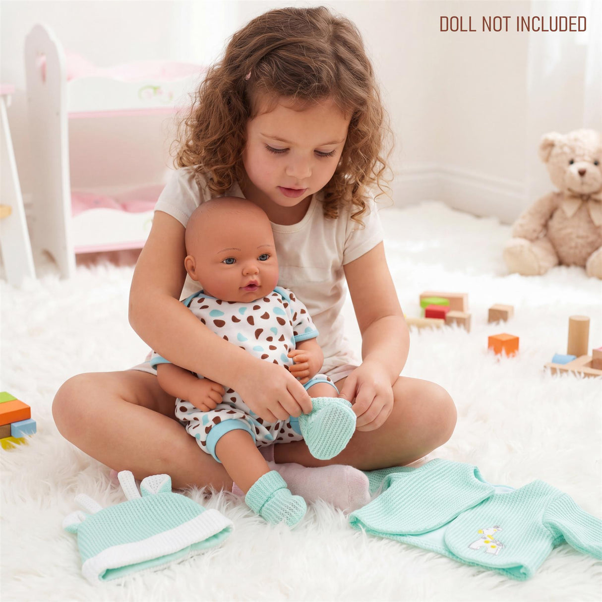Mint green doll clothes, including a jacket and matching booties, are visible on a white rug.