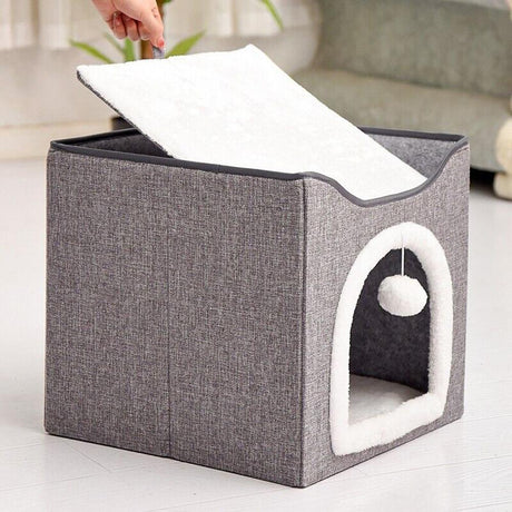 Small cat bed in a blue room, white cat inside, next to a couch. - UKBuyZone