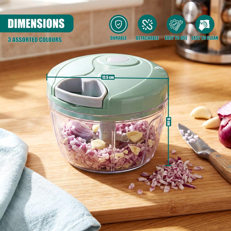 Manual food chopper filled with chopped red onions on a wooden cutting board near a kitchen knife.