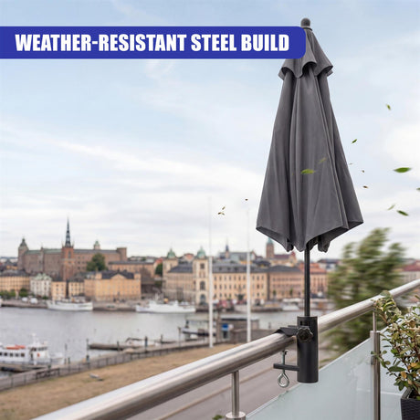 Dark gray patio umbrella attached to a metal clamp securing it to a balcony railing.
